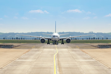 front view of a twin engine big jet plane on an airport taxiway