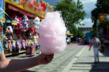 amusement park eating white cotton candy. enjoying a day at amusement park with fresh cotton candy...