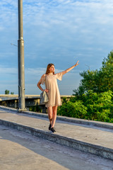 A young girl is walking along the road, a journey.