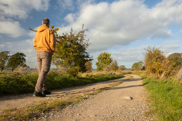 man hiking on a field path