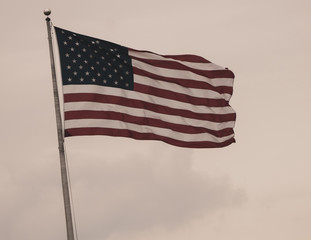 american flag flies high in the sunset