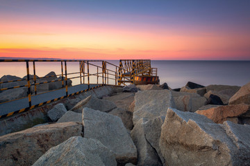 A rocky breakwater overlooking the gulf of Gdansk near the beach at Westerplatte at sunset. Gdansk, Poland