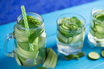 Cucumber infused water with mint on wooden blue background