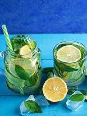 Cucumber chilled infused water with mint and lemon on blue background