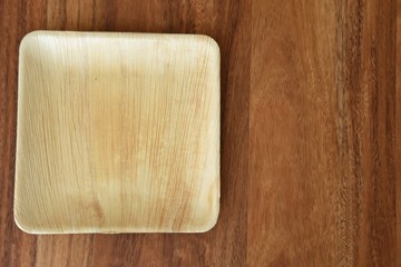 wooden square plate on a brown wooden background