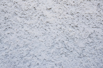 Textured concrete wall with gray, sharp stones.