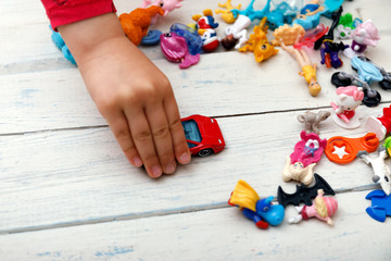 Close up of child's hands playing with colorful plastic bricks at the table. Toddler having fun and building out of bright constructor bricks.