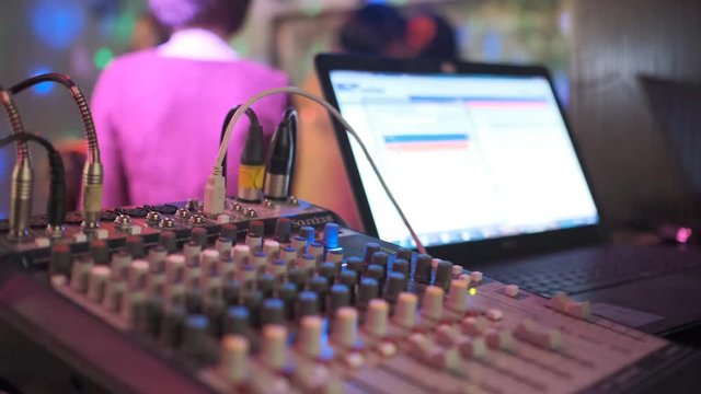 Close up of male hands turning knobs on professional DJ mixer console