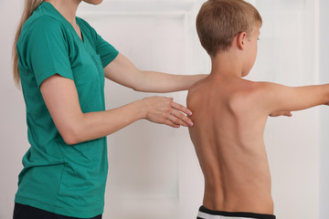 Obraz premium Child having chiropractic back adjustment. Osteopathy, Physiotherapy, Kinesiology. Bad posture correction