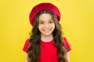 childhood. hairdresser salon. summer fashion and beauty. parisian child on yellow background. happy girl with long curly hair in beret. little girl in french style hat. Fashion portrait of girl
