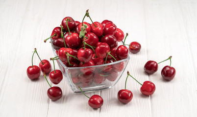 Naklejka na ściany i meble Fresh ripe sweet cherries in bowl on white background