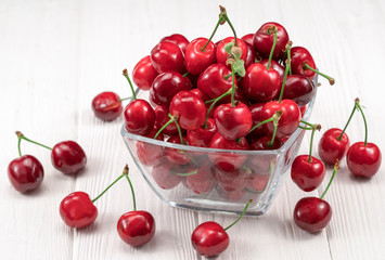 Naklejka na ściany i meble Fresh ripe sweet cherries in bowl on white background