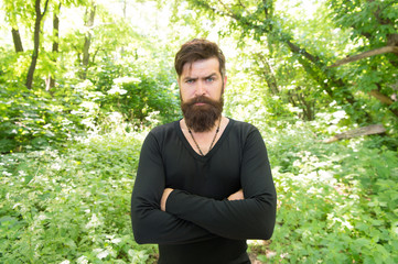 Naklejka na ściany i meble Brutality of jungles concept. Summer heat season concept. Wild nature. Man bearded hipster bright foliage background. Guy relax in summer forest. Handsome man with beard and mustache summer vacation