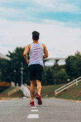 Male runner at sprinting speed training for marathon outdoors