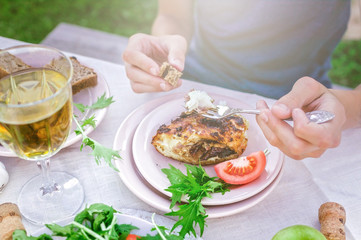 Man eating fried sea fish in the garden at the table. Dinner concept with wine in the fresh air. Fish and salads with vegetables and herbs. Mediterranean Kitchen. Horizontal shot