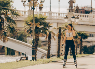 Athletic girl rollerskating  neat the palm trees