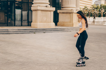 Young fit girl on roller skates riding outdoors