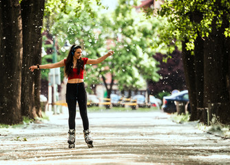 Young woman on roller skates in the summer park