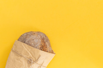 Fresh baked organic whole grain rye bread on bright yellow background