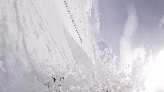 Snowboarder jumping and crashing in powder snow after landing