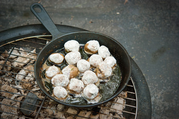 Meatballs in a pan on the coals and grill