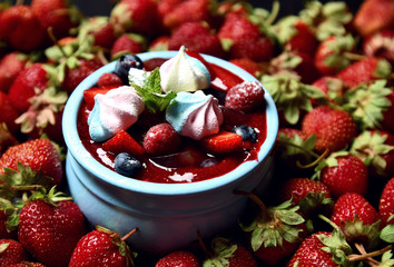 Strawberry and mint desert of fresh ripe  homemade yogurt pana cotta in blue jar on dark background
