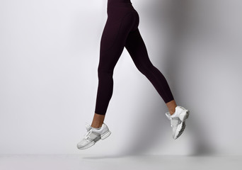 Sporty woman legs walking in sport wear on a white