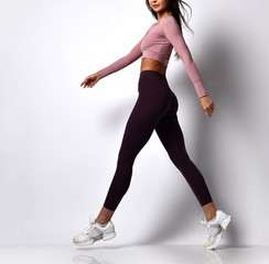 Sporty woman legs walking in sport wear on a white