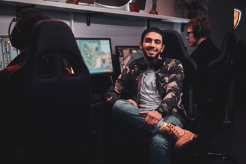 Portrait of afroamerican happy attractive man at cyber gaming club in camo jacket.