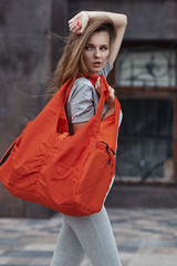 Attracrive sport woman with fittnes sport bag and hat walking outdoor.