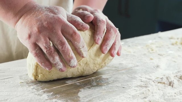 Experienced chef in a professional kitchen prepares the dough with flour to make the Italian pasta, pizza, bread. Сoncept: production of sweets pies pastry, gourmet, pure product, diet and bio