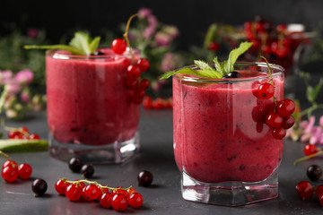 Smoothies with berries in glasses on a dark background, horizontal photo