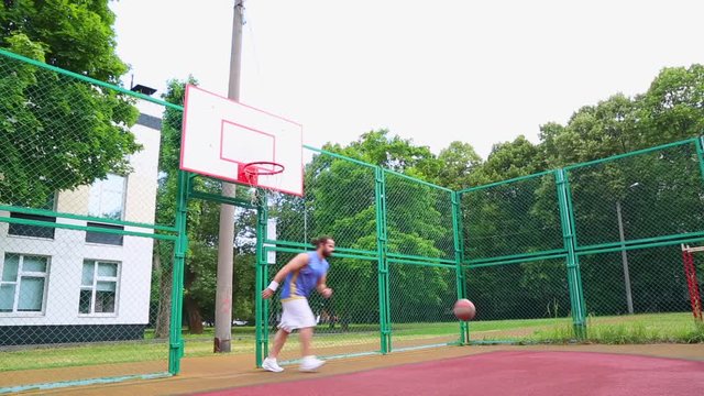 Sport motivation. Street basketball. The player scores the ball in the basket on the street court. Training game of basketball. Concept sport, motivation, goal achievement, healthy lifestyle.
