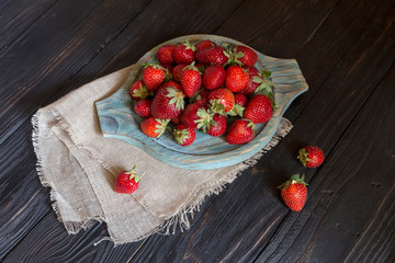 Strawberries on a wooden tray close-up on a wooden table