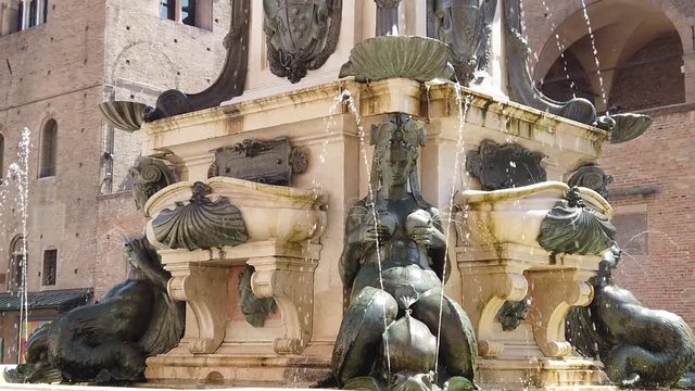 SLOW MOTION: Medieval architecture of Bologna. Neptune statue and restored fountain of Bologna town of Italy. Perspective view from bottom.