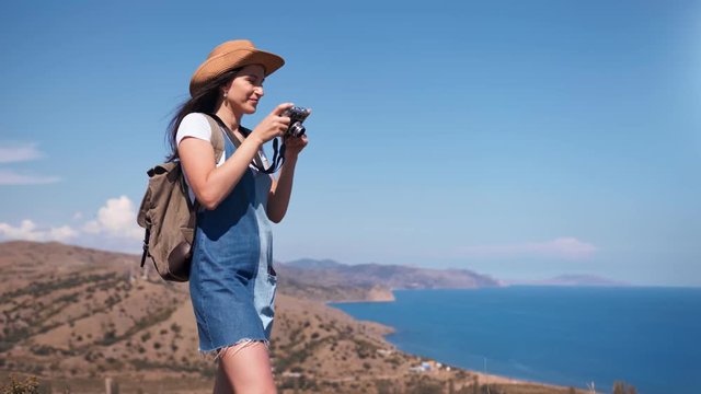 Active tourist happy woman taking picture of amazing nature seascape using camera