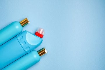 Blank blue plastic bottles in the left part background. Household chemistry, shampoo, cleaner.