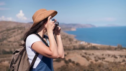Adorable relaxed female tourist taking picture of beautiful nature using camera medium shot