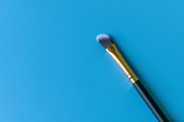 Naklejka premium Makeup brush on a blue background