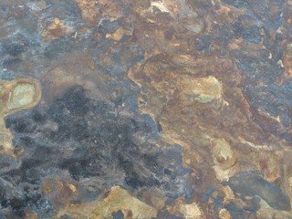 Rock heavily eroded by river water. Shifting colors and patterns. Background, overlay, or blending element.