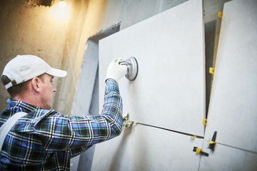 Tiler installing large format tile on wall. home indoors renovation