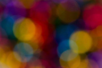 blurred bokeh bright multicolored iridescent glowing gold dimming beads spread on the table background