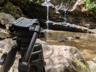 Tripod set up next to waterfall