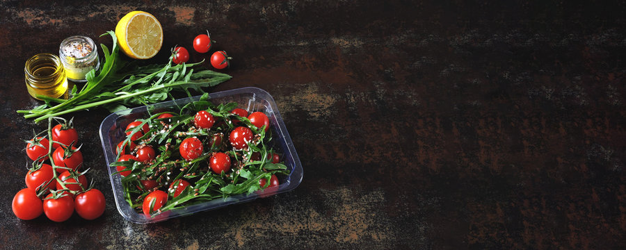 Healthy salad in the lunchbox. Arugula salad and cherry tomatoes with seeds to go. Keto diet Banner.