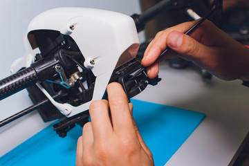 Closeup shot of man working on assembling new surveillance system using quadcopter drone with...