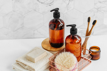 Toiletries tube in a bathroom interior, shower gel, shampoo and bamboo toothbrushes.