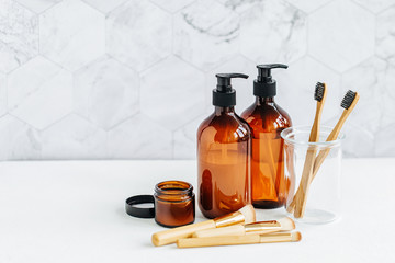 Toiletries tube in a bathroom interior, shower gel, shampoo and bamboo toothbrushes.