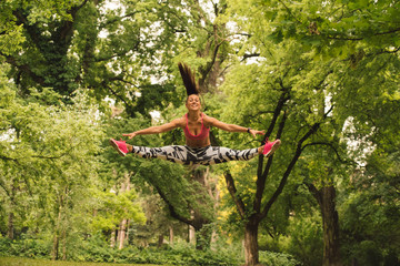  A beautiful fitness girl trains in the park. Nature and healthy life