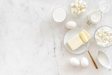 Eggs, butter, milk, yougurt, cottage for natural farm products yougurt marble background top view monochrome copyspace