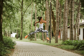  A beautiful fitness girl runs in the park. Nature and healthy life